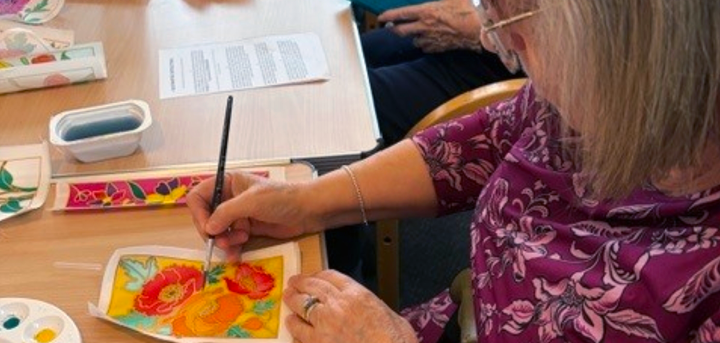 A member of the Coffee and Crafting Club trying silk painting