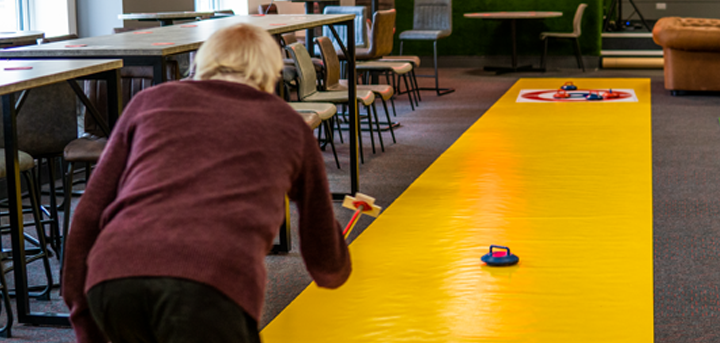 An older person trying indoor curling