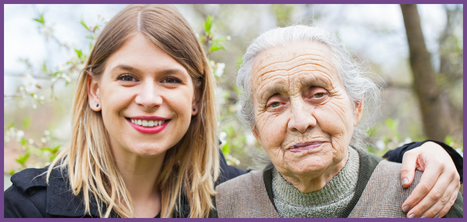 Volunteer and older lady smiling at camera