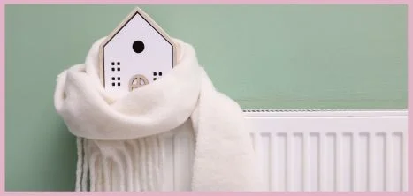 Model house wrapped in a scarf, placed on a radiator