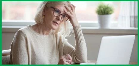 Older lady looking stressed at a laptop