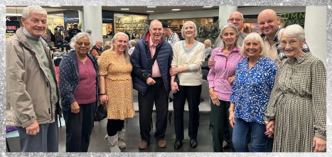 Older people stood in a group at Silver Sunday event, smiling at the camera