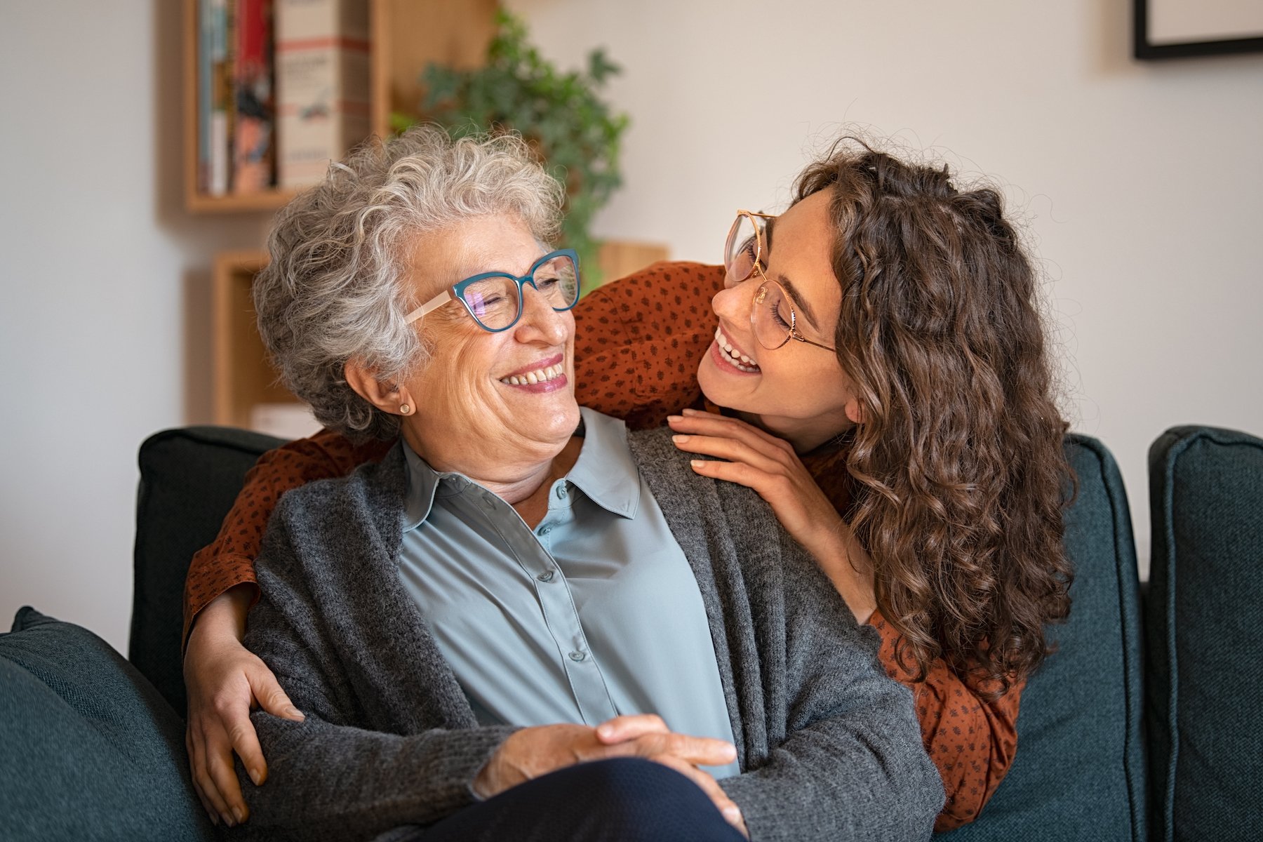 Older woman being hugged by her daughter 