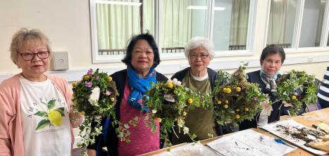 Ladies holding decorative wreaths