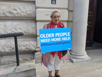 Elsie Hall-Thompson holding an Older People Need More Help poster