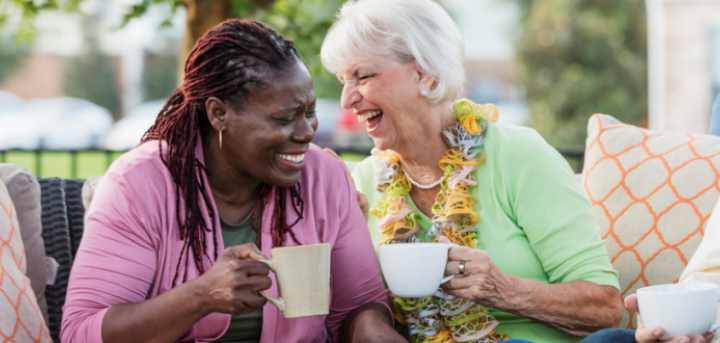 Two ladies laughing while having a coffee