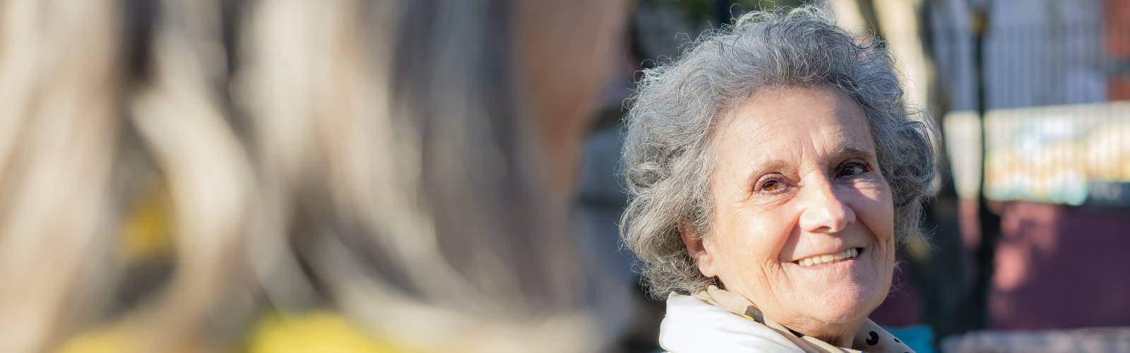 An older woman smiles at a friend