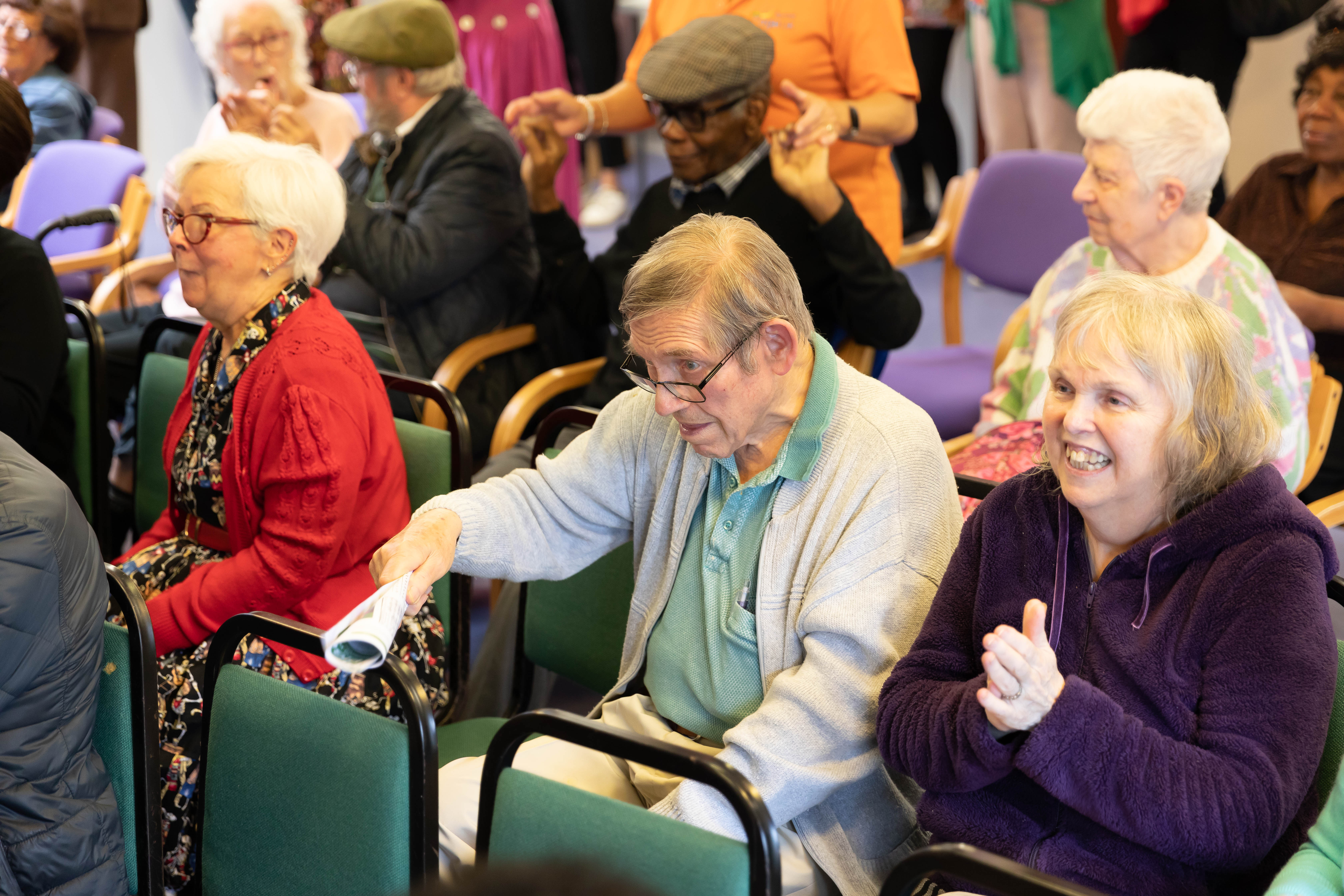 Age UK Barnet listening to the steel pan orchestra and Levi's talk