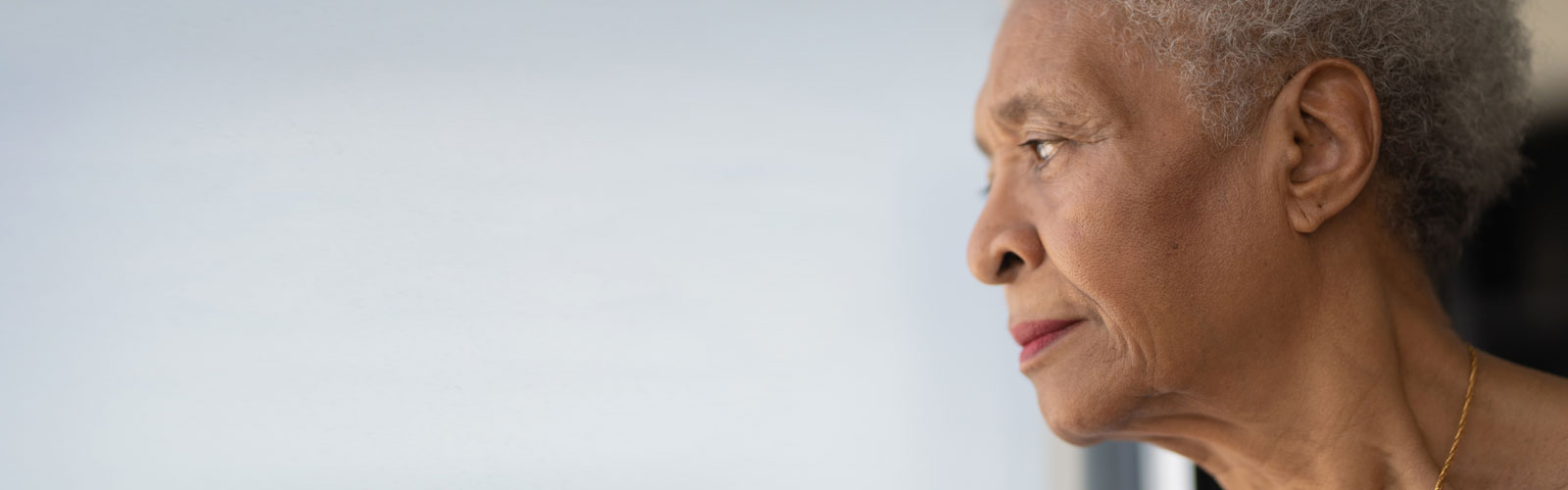 Bridgit, an older Black woman, looks out of her window