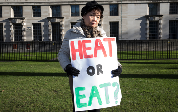 Image of woman holding a 'HEAT OR EAT?' sign