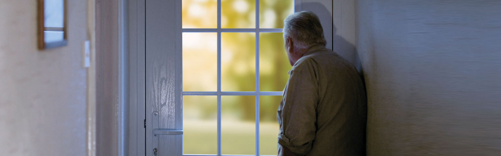 A man stood, looking out of the window