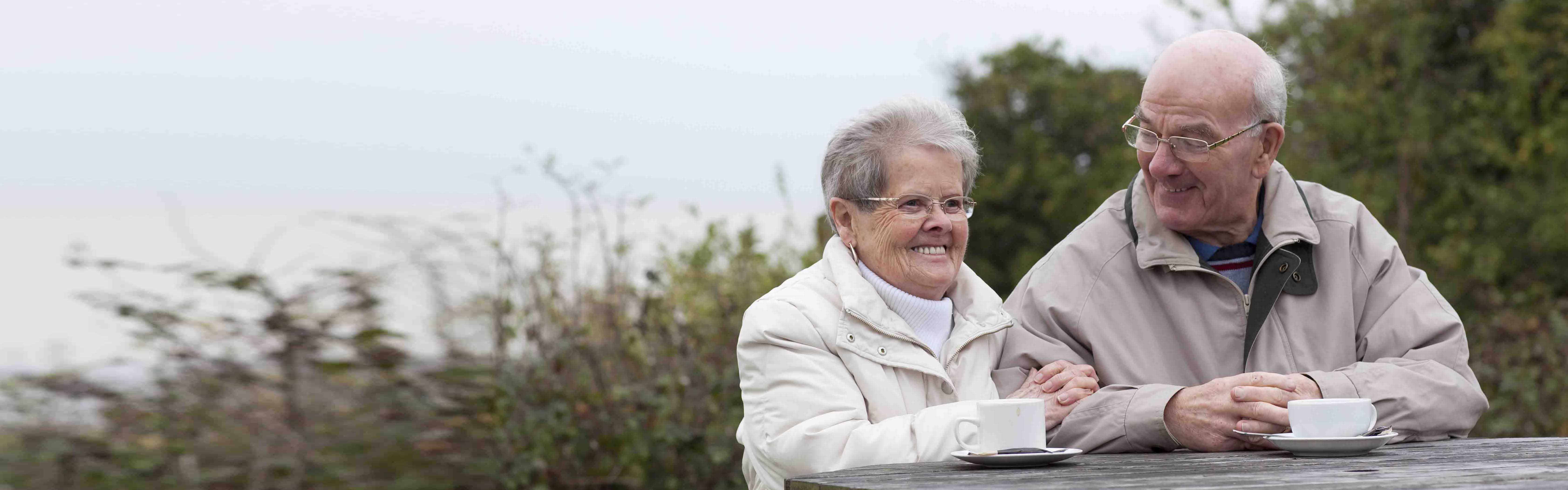 An older couple sitting having a cup of tea