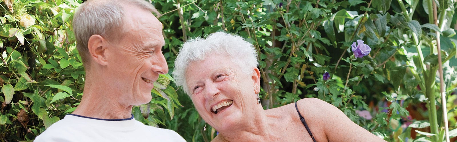 An older man and woman sat together, laughing