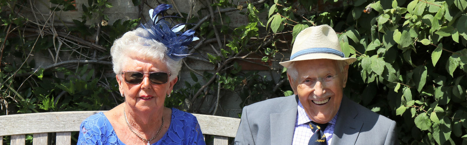 An older man and woman, sat on a bench
