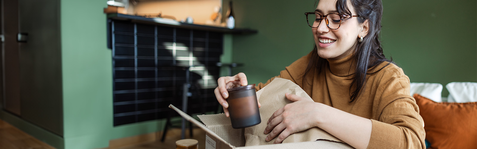 Woman looks pleased as she opens a delivery box in her home