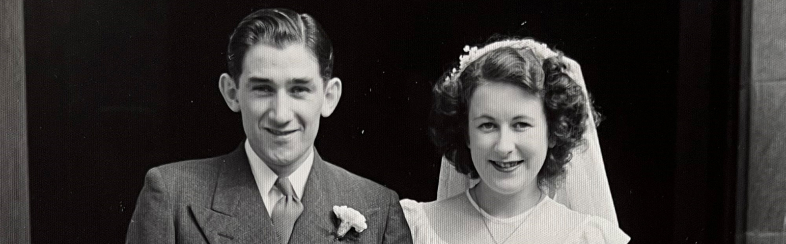 A black-and-white photo of a young man and woman on their wedding day