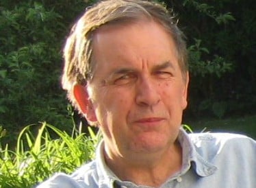 David Vincent, in a blue shirt, sat out doors with plants behind him