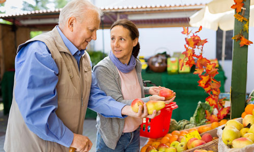 Older couple shopping for fruit and veg.