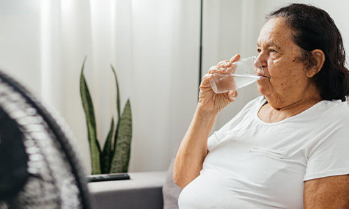 An older woman sat down, drinking a glass of water
