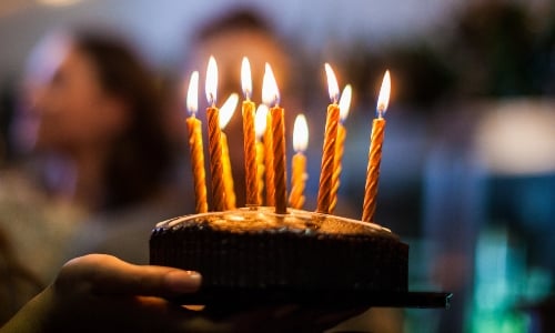 A girl holds a birthday cake