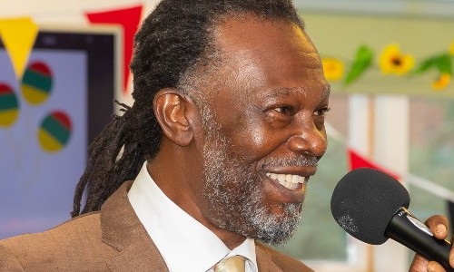Levi Roots, smiling while holding a microphone