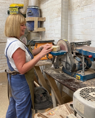 A middle aged woman with blonde hair at work in a workshop