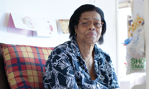 A woman sitting in her living room looking at the camera