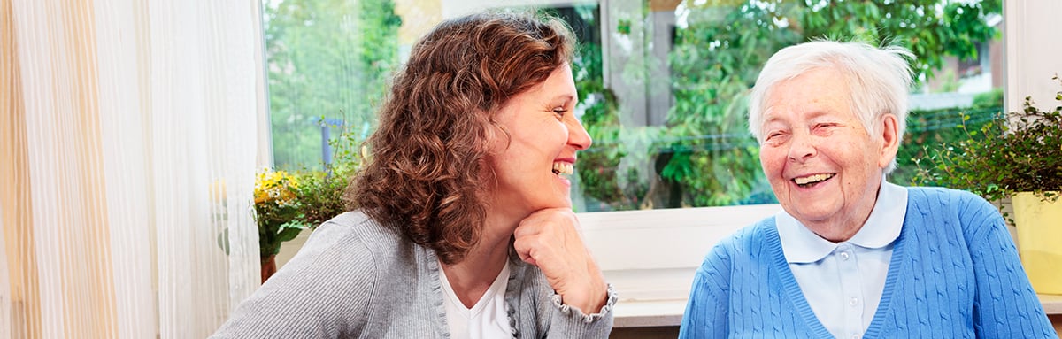 An older woman and a younger woman sit talking together