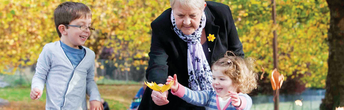 Older woman playing with children in a park