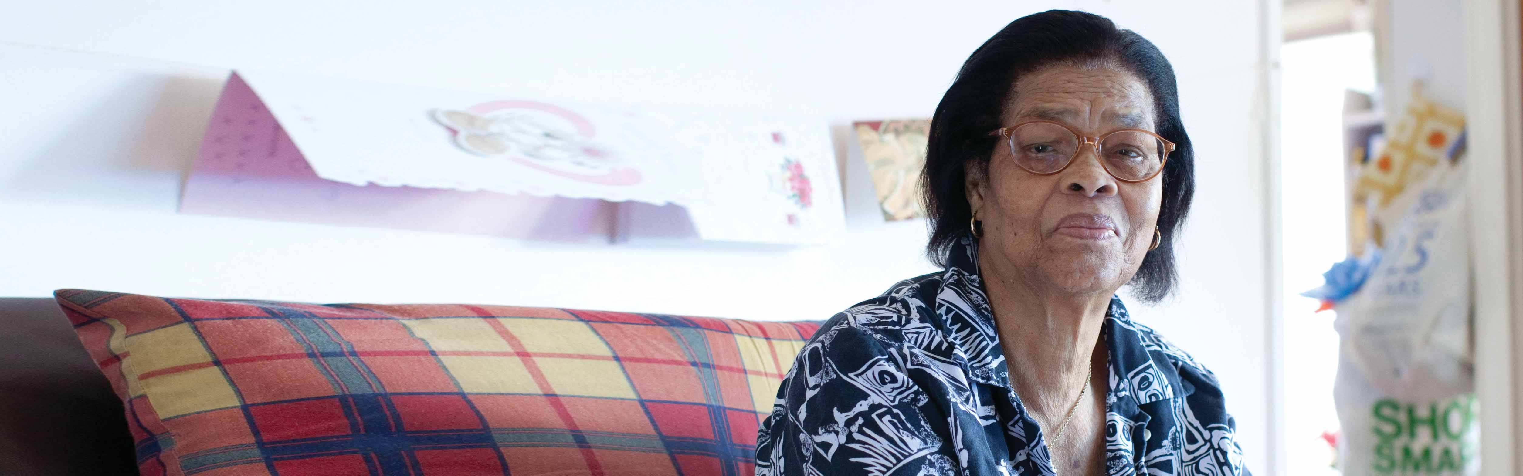 An older Black woman sits alone