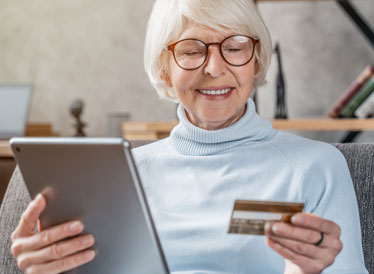 Woman holding tablet and credit card whilst online shopping