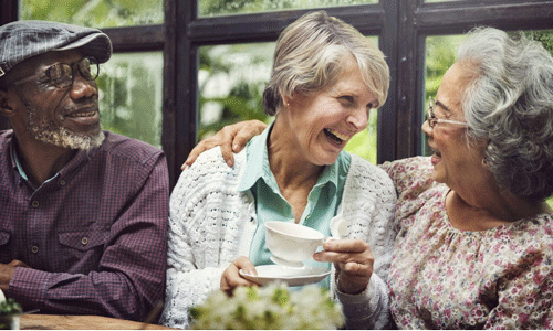 one man and two women laughing together