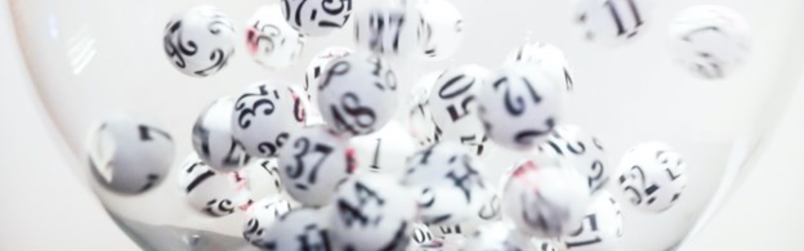 a glass bowl full of numbered lottery balls