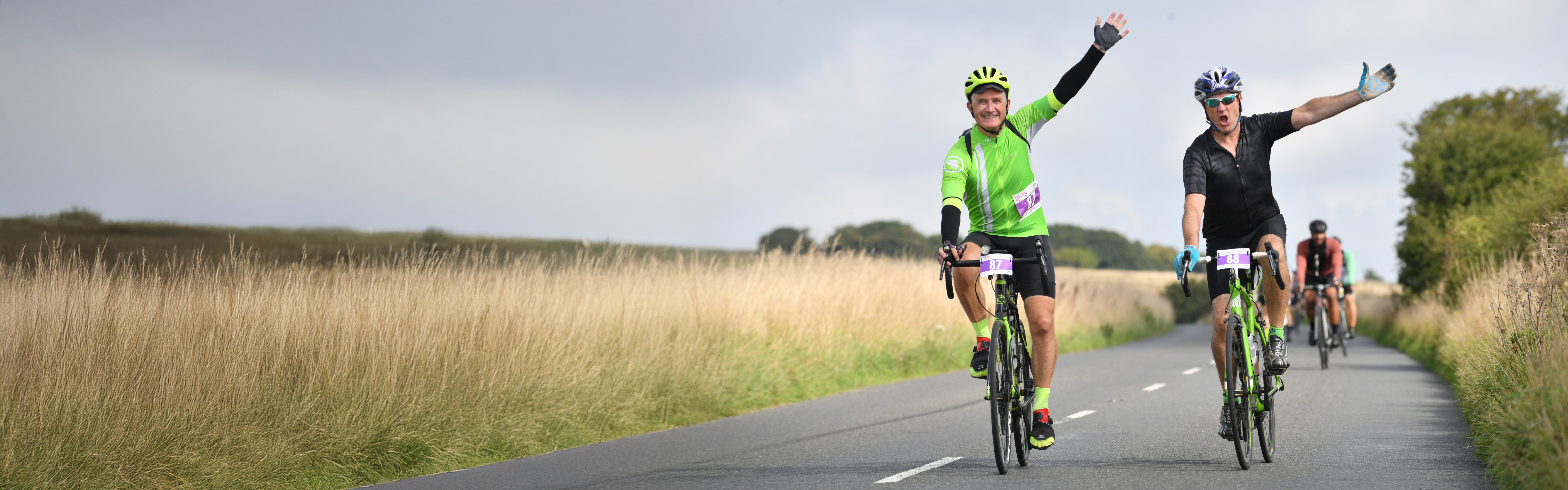 Two middle-aged men on bikes, completing the London to Brighton cycle ride