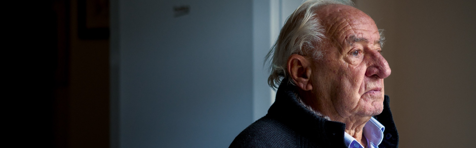 An older man in profile, looking pensive