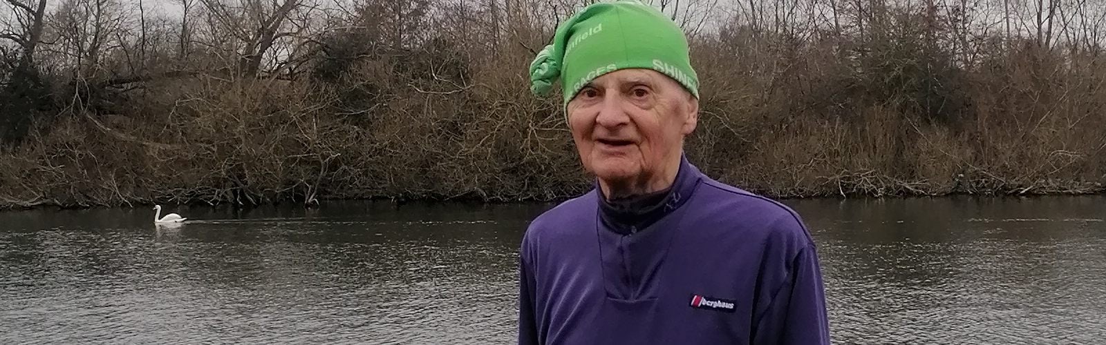 Tom, an Age UK fundraiser, stood in his running gear next to a river