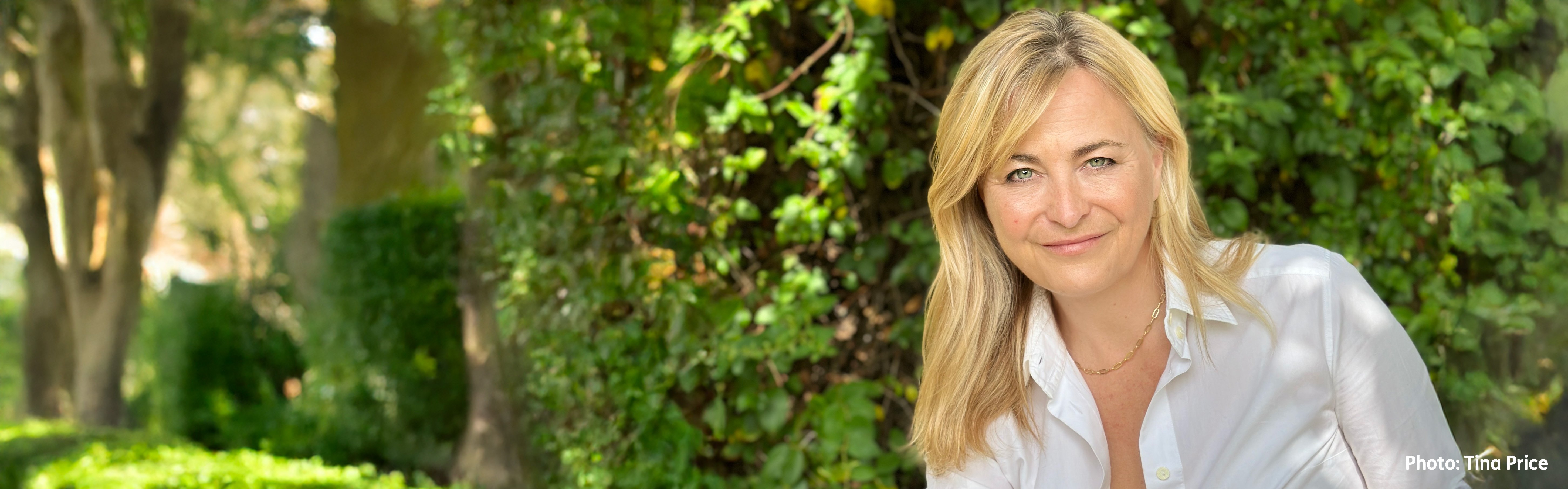 A photo of a middle-aged blonde woman, in woodland