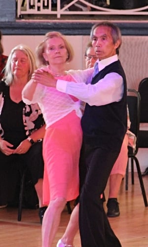 An older Asian man and his partner dancing the tango