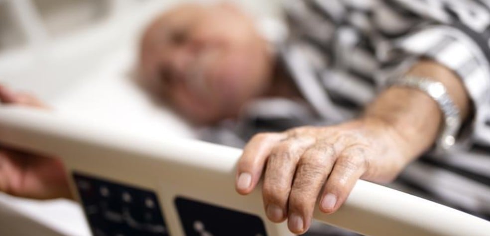 An older person lies on a trolley in A&E